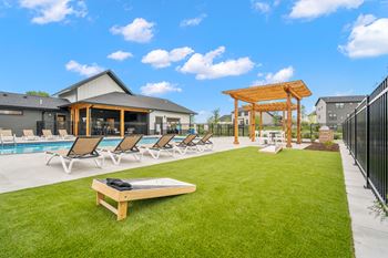 A sunny day at the pool with lounge chairs and a gazebo.